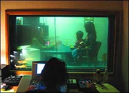 audiologist Florence Himelfarb operates the clinical audiometer while audiometrist Melissa Cabrera keeps 2-year-old Nathan focused