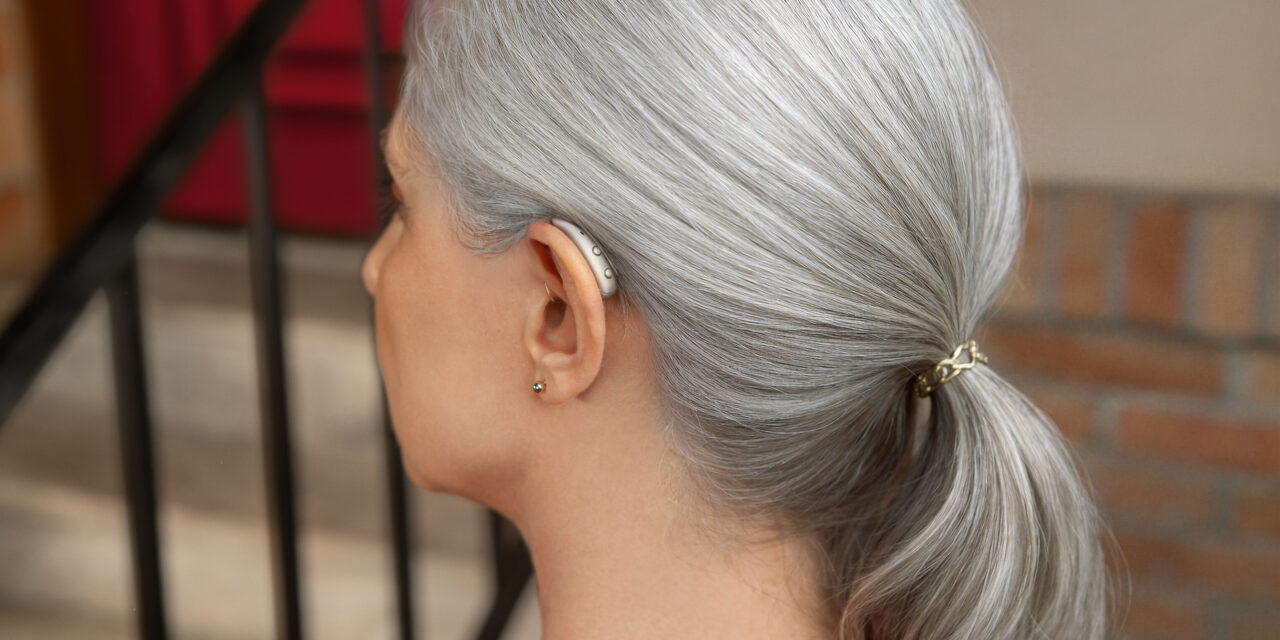 Signia MaX Pure C&G MaX RIC hearing aid worn by a senior woman, side view